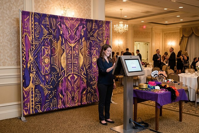 Open-air photo booth with a custom backdrop at a wedding reception